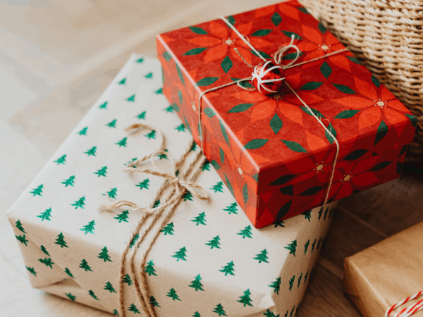 Photographie de cadeaux emballés sur un fond uni.